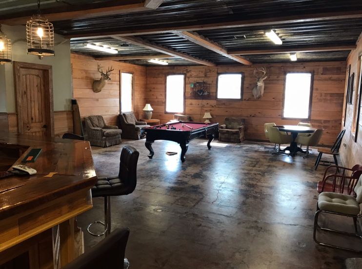 Delta Outdoors Co. lodge game room with a pool table, seating, and bar area for guests after the hunt.