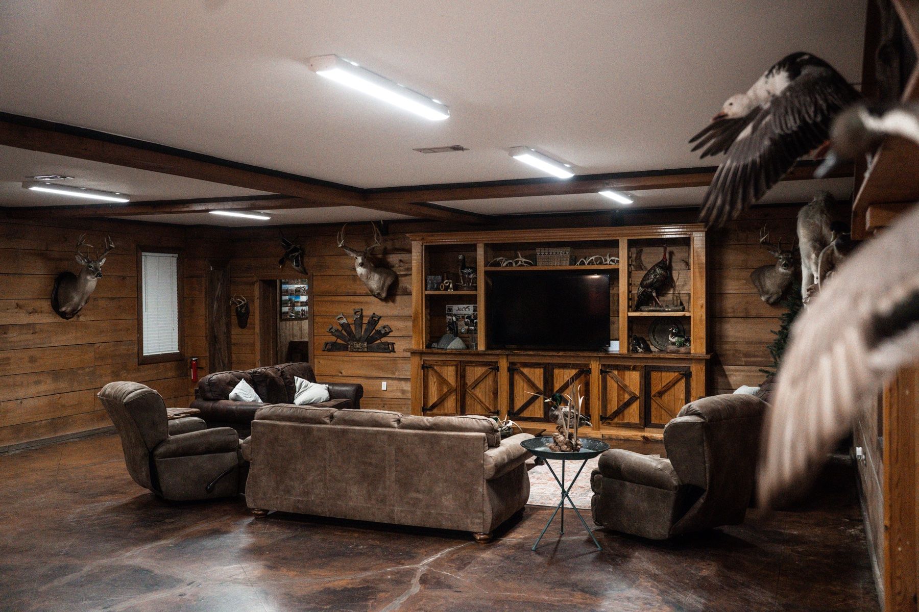 Delta Outdoors Co. lodge great room with couches, mounted wildlife, and space for guests to relax after a duck hunt.