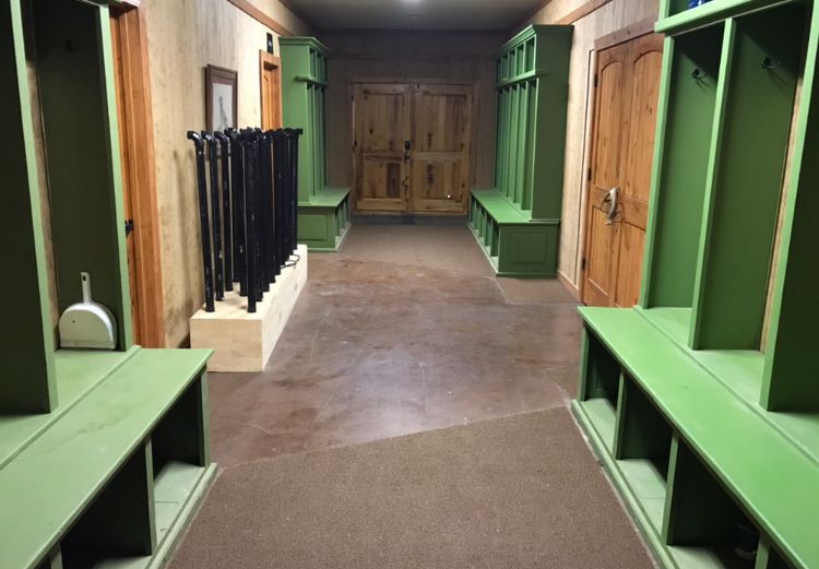 Delta Outdoors Co. lodge mudroom with green gear storage cubbies for hunting guests.