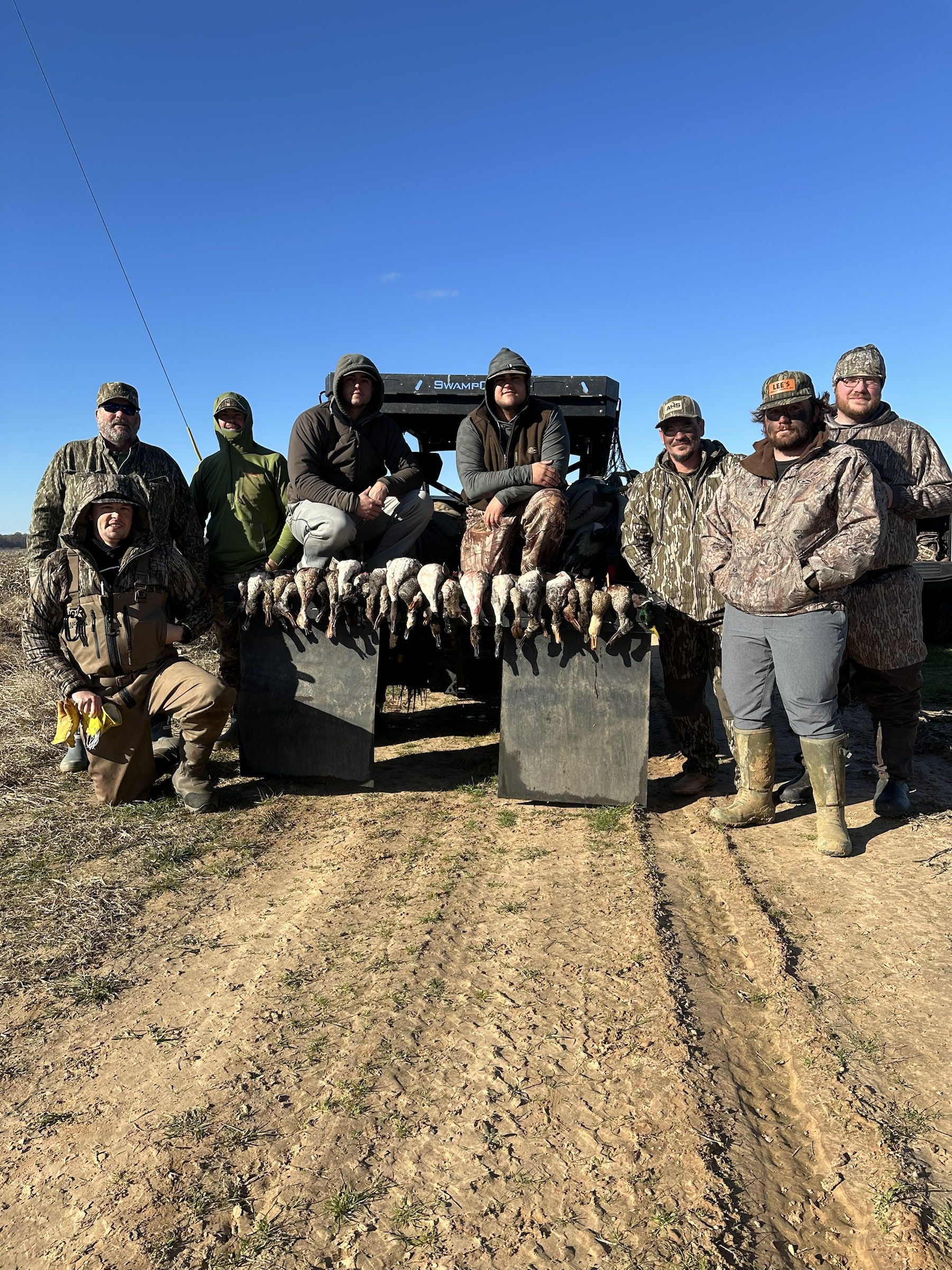 Delta Outdoors guests gathered near a side-by-side with birds displayed after a hunt.