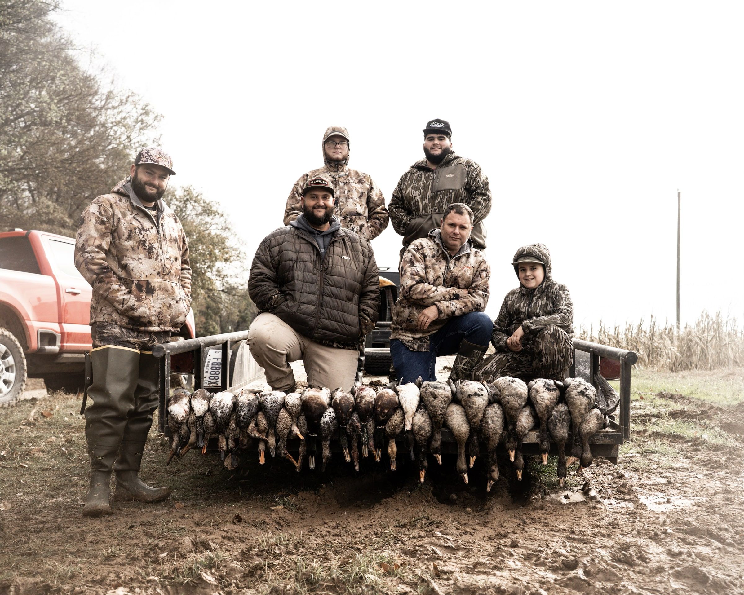 Delta Outdoors guests posing with birds on a foggy morning after a hunt.